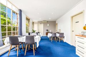 墨尔本格林波罗康福特茵酒店的一间设有白色桌椅和窗户的用餐室