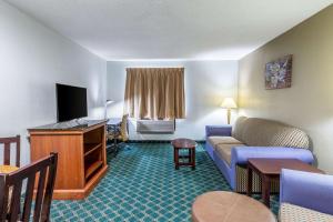 AuburnEcono Lodge Inn & Suites的一间配备有沙发及电视的酒店客房