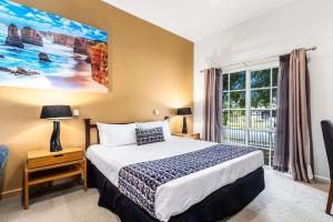 墨尔本格林波罗康福特茵酒店的一间卧室设有一张大床和一个窗户。
