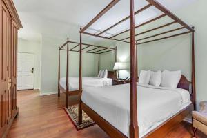 巴尔的摩Admiral Fell Inn Baltimore Harbor, Ascend Hotel Collection的一间卧室配有两张带白色床单和木地板的床。