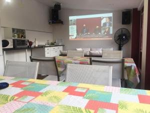 AlgeteCasa de sol, piscina y jacuzzi con 4 hab en Comunidad de Madrid的一间带桌椅和屏幕的用餐室