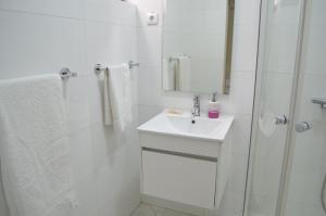 普拉亚LT Aparthotel的白色的浴室设有水槽和淋浴。