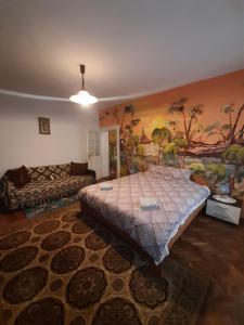 锡比乌Alex-Gabriel的卧室配有一张床,墙上挂有绘画作品