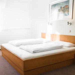 新维德Hotel Imota的一张铺有白色床单的床和一张墙上的照片