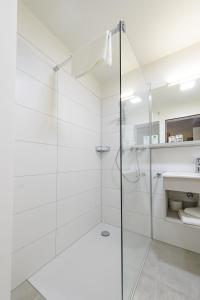 康斯坦茨Gasthaus Adler Allmannsdorf的白色浴室设有玻璃淋浴间