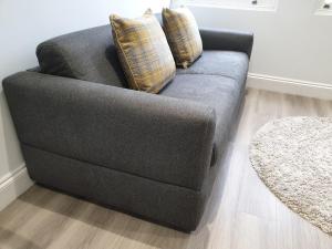 伦敦2-bed Notting Hill / Portobello的客厅里配有带两个枕头的灰色沙发