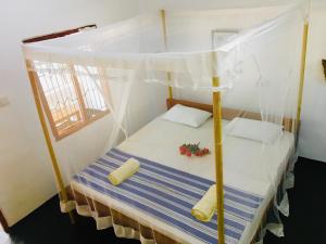 阿鲁甘湾Beach Wave Hotel的一张带天蓬的床