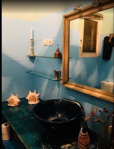 马普托Guesthouse MALAGUETA INN I & II的浴室设有黑色水槽和镜子