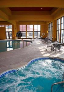 Pewaukee佩​​沃基-密尔沃基西部假日酒店的一座配有桌椅的大型游泳池