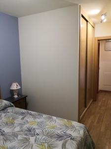 奥维多Apartamentos Chevere Azul的一间卧室配有一张床和一张桌子上的台灯
