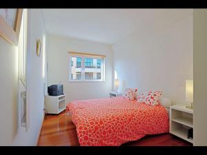 里斯本世博会舒适当代旅馆的白色的卧室设有红色的床和窗户