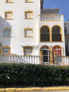 托雷维耶哈Geraneos Playa的白色的房子,有白色的围栏