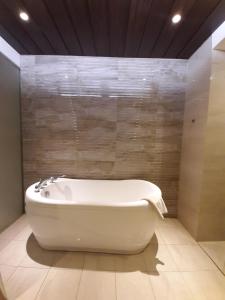 Sumedang素么当阿斯丽酒店的浴室配有白色浴缸,浴室设有墙壁