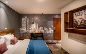 特拉维夫Embassy Hotel Tel Aviv的配有一张床和一张书桌的酒店客房