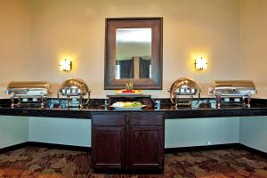 格雷特纳新奥尔良西岸大厦假日酒店的一间酒吧,位于酒店客房内,配有椅子和镜子