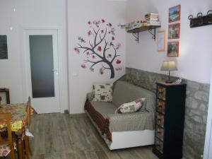 特拉西梅诺湖畔托罗La Poventa的客厅配有沙发,墙上挂着一棵树