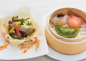 甲府Konaya Hotel的盘子上放着一碗食物和一碗蔬菜