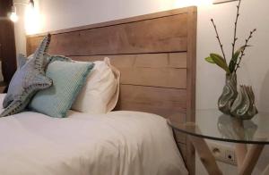马塞克Anthos B&B的一张带木制床头板和玻璃桌的床
