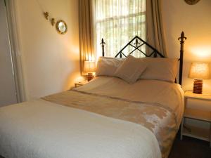 布里奇诺斯Stoneway Guest House的一间卧室配有一张带两盏灯的床和一扇窗户。