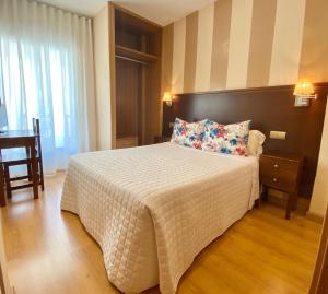 马尔托斯Hotel Fernando IV的卧室配有一张带白色棉被的大床