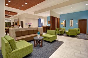 加尔维斯敦Holiday Inn Express & Suites - Galveston Beach, an IHG Hotel的大堂设有绿色椅子、沙发和桌子