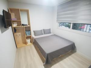 济州市Yong Stay的一间小卧室,配有一张床和电视