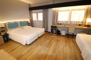 米兰多梅尼基诺酒店的酒店客房配有两张床和一张书桌
