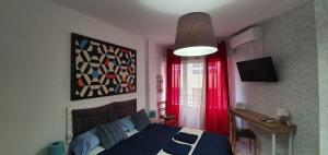 阿利坎特Centric Rooms Mercado的一间卧室配有蓝色的床和红色窗帘