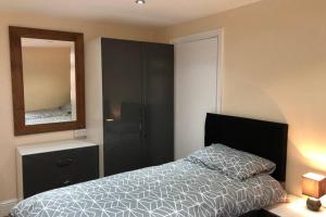 曼彻斯特133B PARK ROAD STRETFORD MANCHESTER的一间卧室配有一张床和镜子