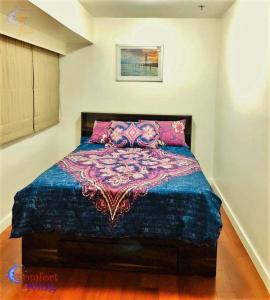 马尼拉BGC Fort Victoria的一间卧室配有一张带彩色毯子的床