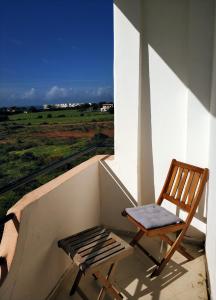 丹吉尔Achakar Hills , Piscine , Vue & Accès à la mer的坐在门廊上的椅子,享有田野的景色