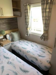 沃切特3 bed presitage caravan Doniford Bay的小型客房 - 带2张床和窗户