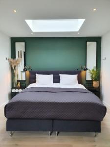 登堡Studio Smidt的一间卧室设有一张大床和绿色的墙壁