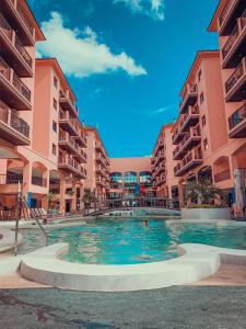 弗洛里亚诺波利斯Jurerê Beach Village - Flat na Praia的两个公寓大楼中间的一个游泳池