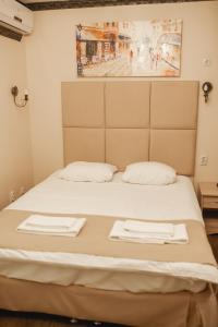 秋明Traveler's Mini-Hotel的一张带两张白色毛巾的床