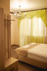 秋明Traveler's Mini-Hotel的一间卧室设有两张床、一个吊灯和一个窗户。