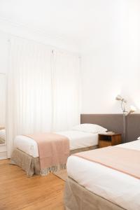 里斯本里斯本欣悦公寓的一间卧室设有两张床和窗户。