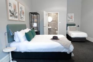 悉尼The Alison Randwick的一间卧室配有一张大床,上面有帽子