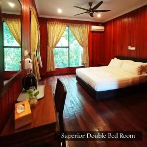 山打根Kinabatangan Wildlife Lodge的卧室配有一张床、一张书桌和窗户。