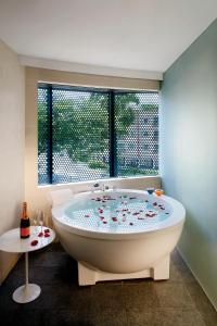 新加坡D'Hotel Singapore managed by The Ascott Limited的窗户客房内的白色大浴缸