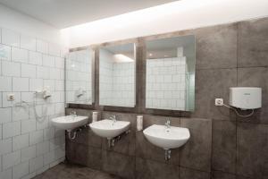 雅加达Bobopod Kota Tua, Jakarta的浴室设有2个水槽和2面镜子