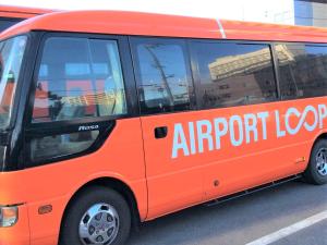 泉佐野泉佐野中心关西国际机场酒店的一辆橙色面包车,上面写着机场环