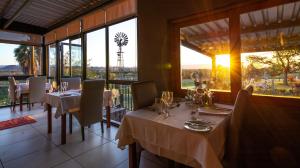 奥茨胡恩德兹科农家乐酒店的用餐室设有桌椅和窗户。