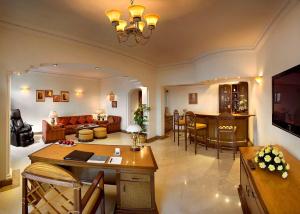 新德里新德里苏尔亚酒店的客厅配有沙发和桌子