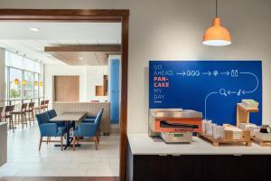 西得梅因Holiday Inn Express & Suites - West Des Moines - Jordan Creek, an IHG Hotel的餐厅拥有蓝色的墙壁,配有桌椅