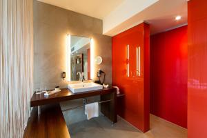 克拉根福Seepark Wörthersee Resort的一间带水槽和红色墙壁的浴室