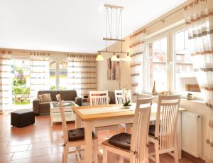 蒂门多夫Haus Seeschwalbe的厨房以及带桌椅的起居室。