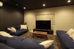 姶良市照宿 Terasu yado的客厅配有蓝色的沙发和平面电视。