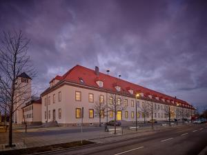 新特劳布灵Apartment:house Klosterbau的一条街道上一座白色的大建筑,有红色的屋顶