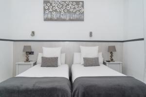 马德里63号大道旅馆的两张位于酒店客房的床,配有两个枕头